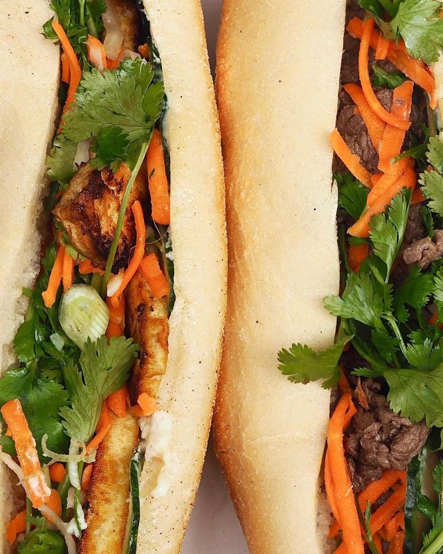 Un bánh mì vu de près, débordant de carottes, de coriandre et de viande grillée