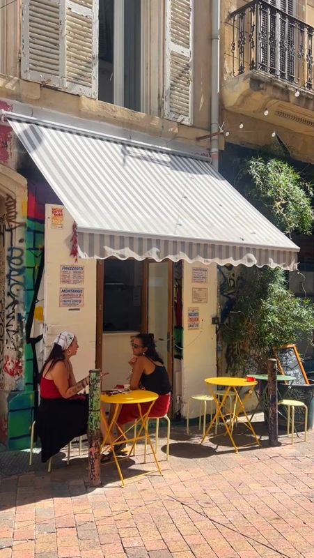 La terrasse de Panpan Zerotti rue Pastoret, ses chaises jaunes sous le store blanc