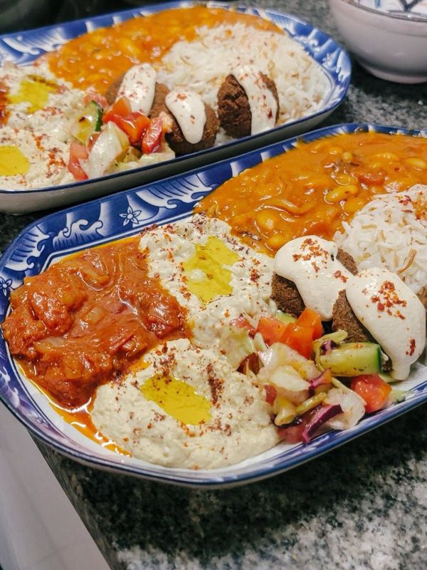 Deux grandes assiettes de mezzés, falafels, houmous et salades, vues du dessus