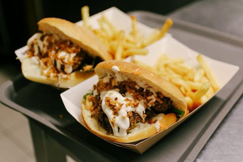Deux sandwichs garnis et des frites dans une barquette