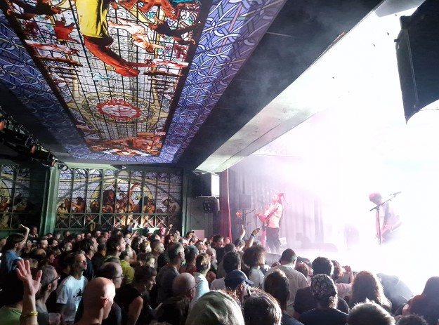 La foule devant la scène de l'Espace Julien, sous le plafond peint et coloré de la salle